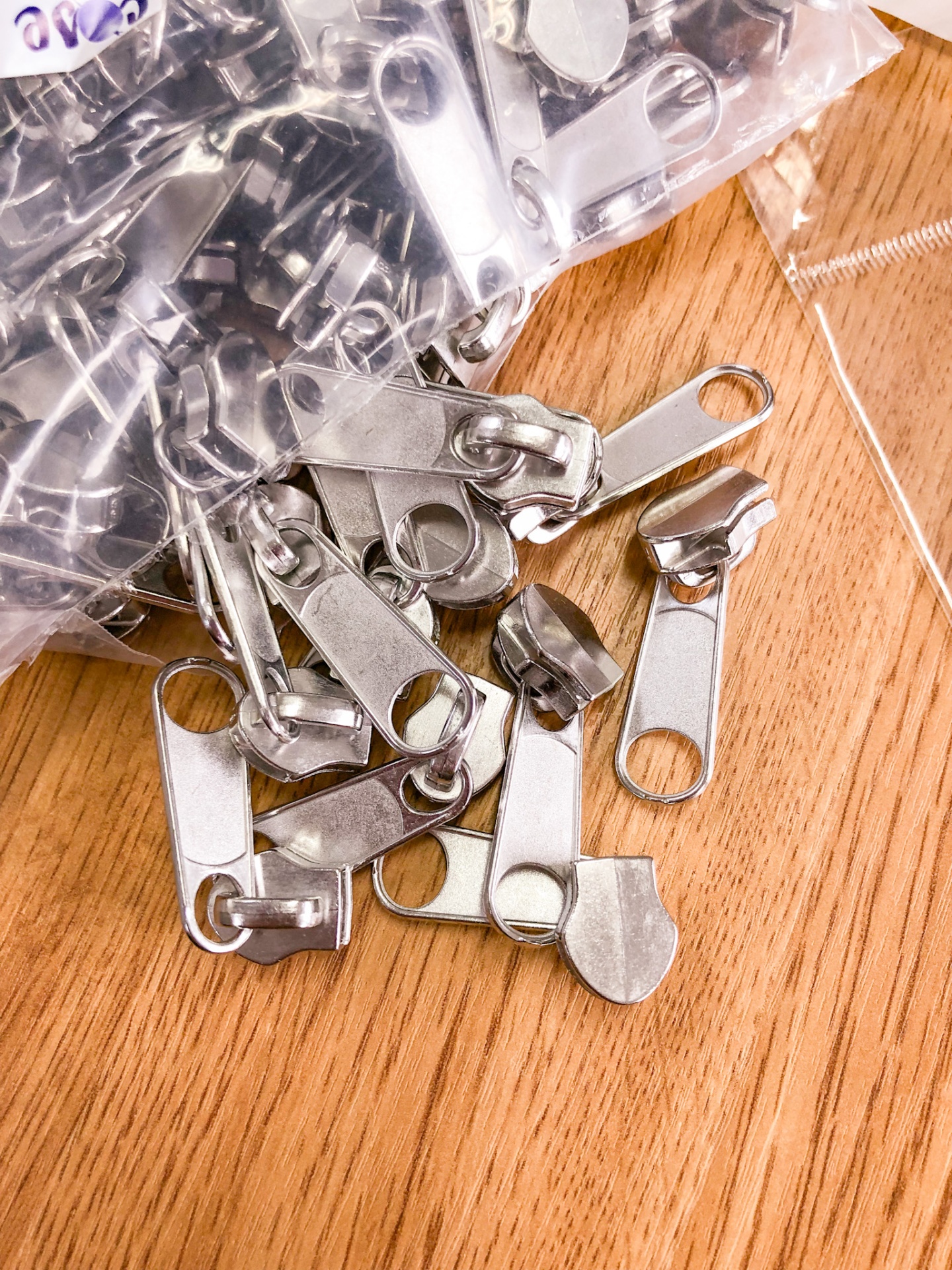 Cursores de zíper metálicos prateados sobre madeira