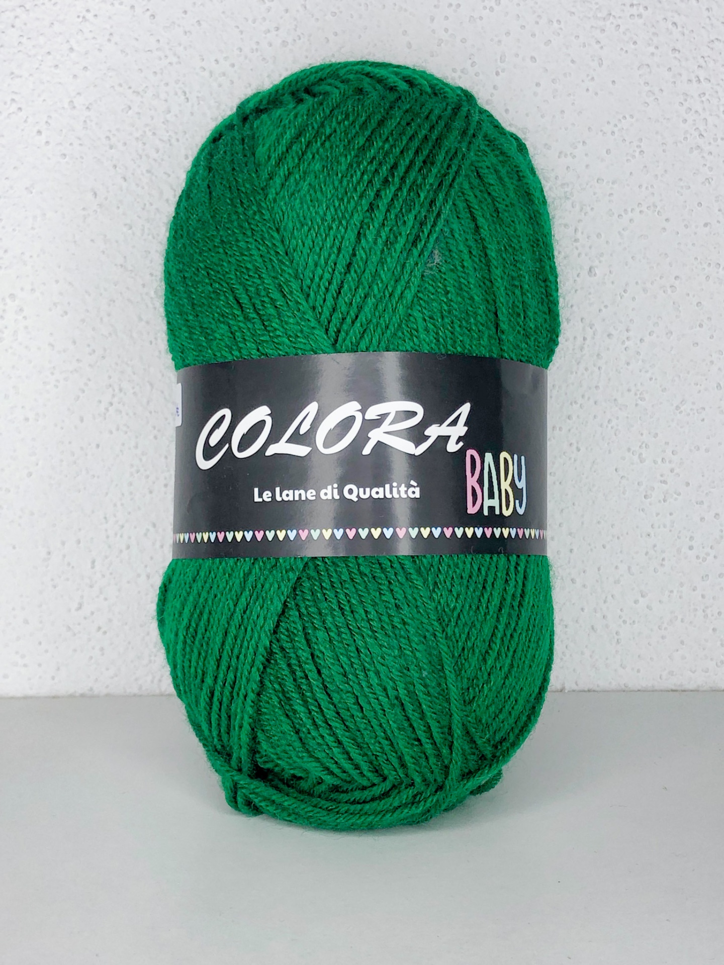 Novelo de lã verde com etiqueta preta COLORA BABY