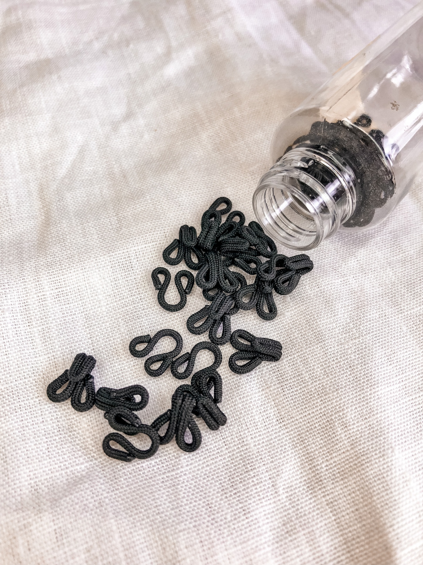 Frasco com ganchos pretos em tecido creme