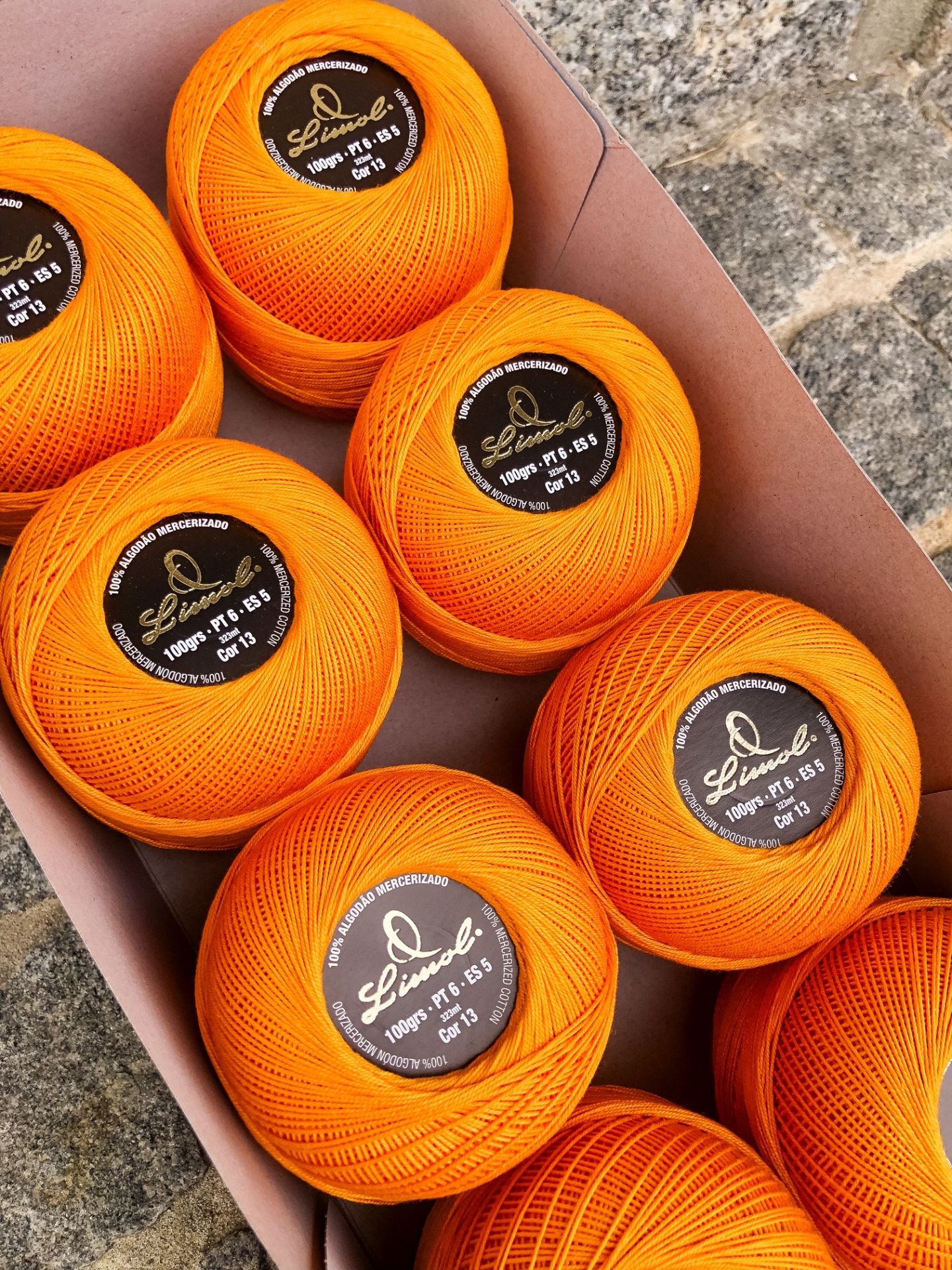 Novelos de linha de algodão laranja em caixa de cartão