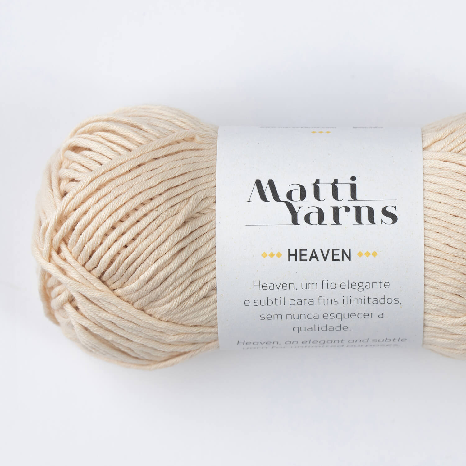 Novelo de fio de lã bege claro com etiqueta branca 'Matti Yarns HEAVEN'