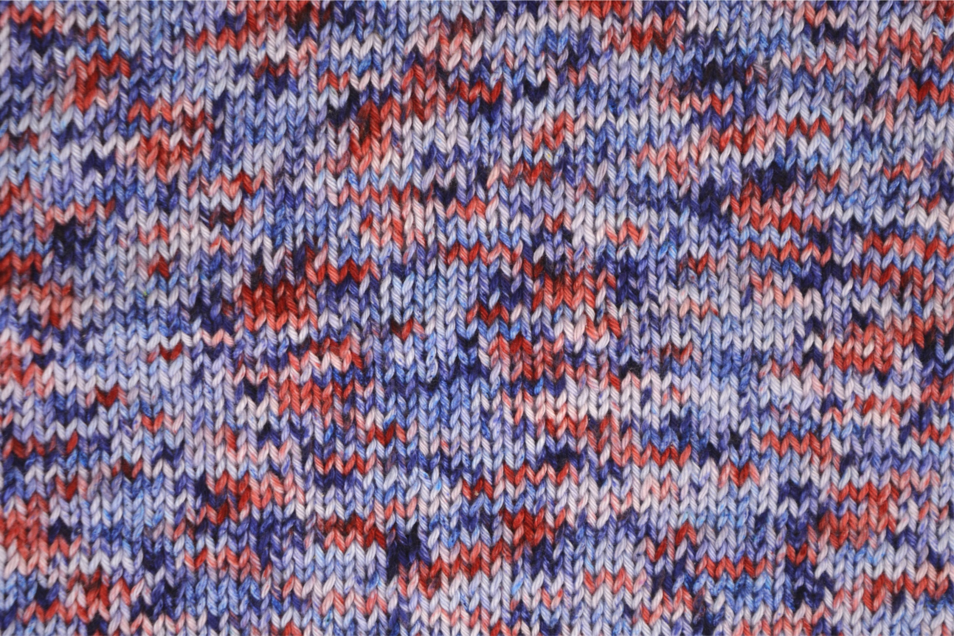 Tecido de malha mesclado em tons de azul, lilás, vermelho e roxo