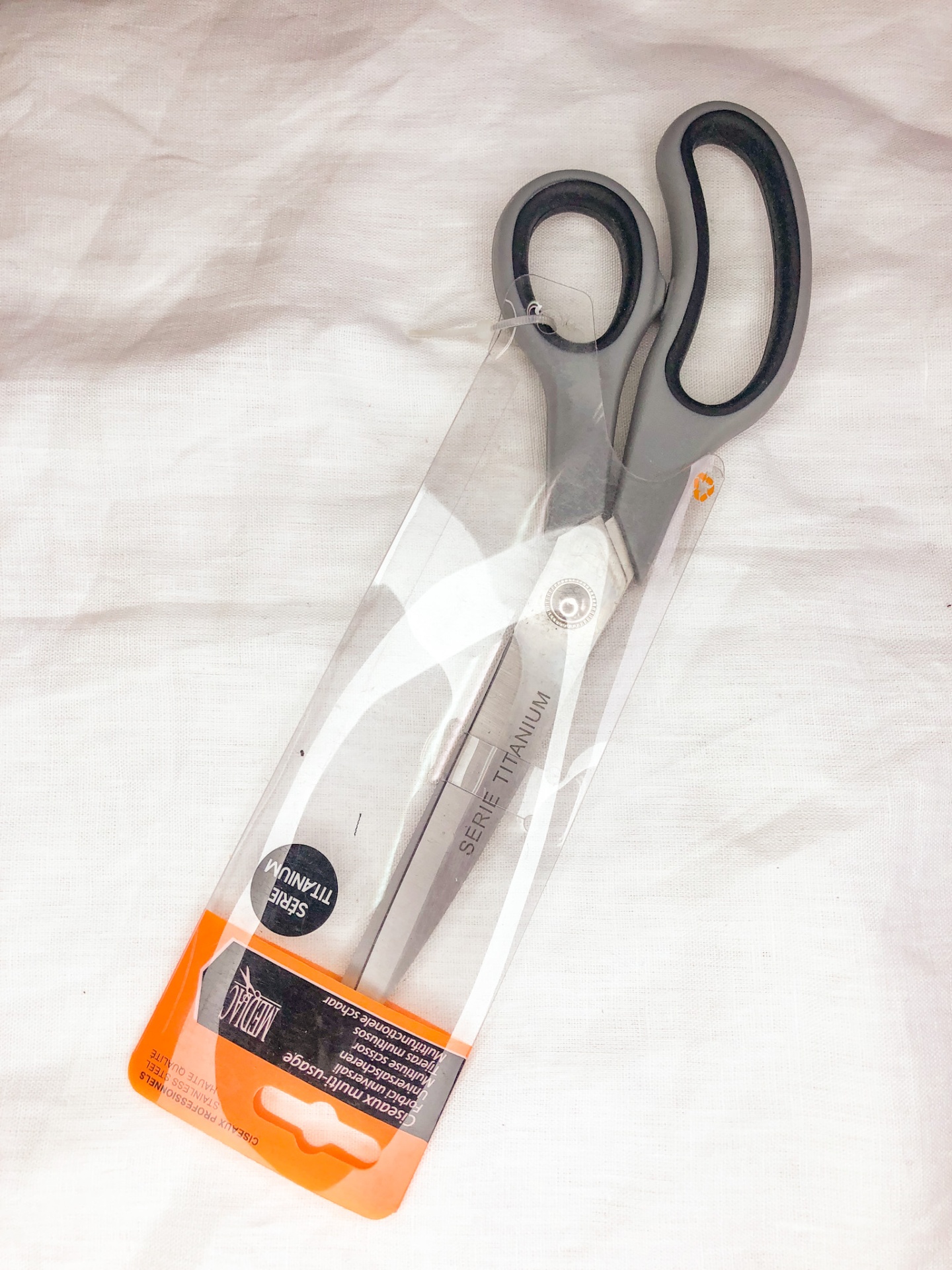 Tesoura com cabo preto e lâminas de aço inoxidável em embalagem plástica transparente