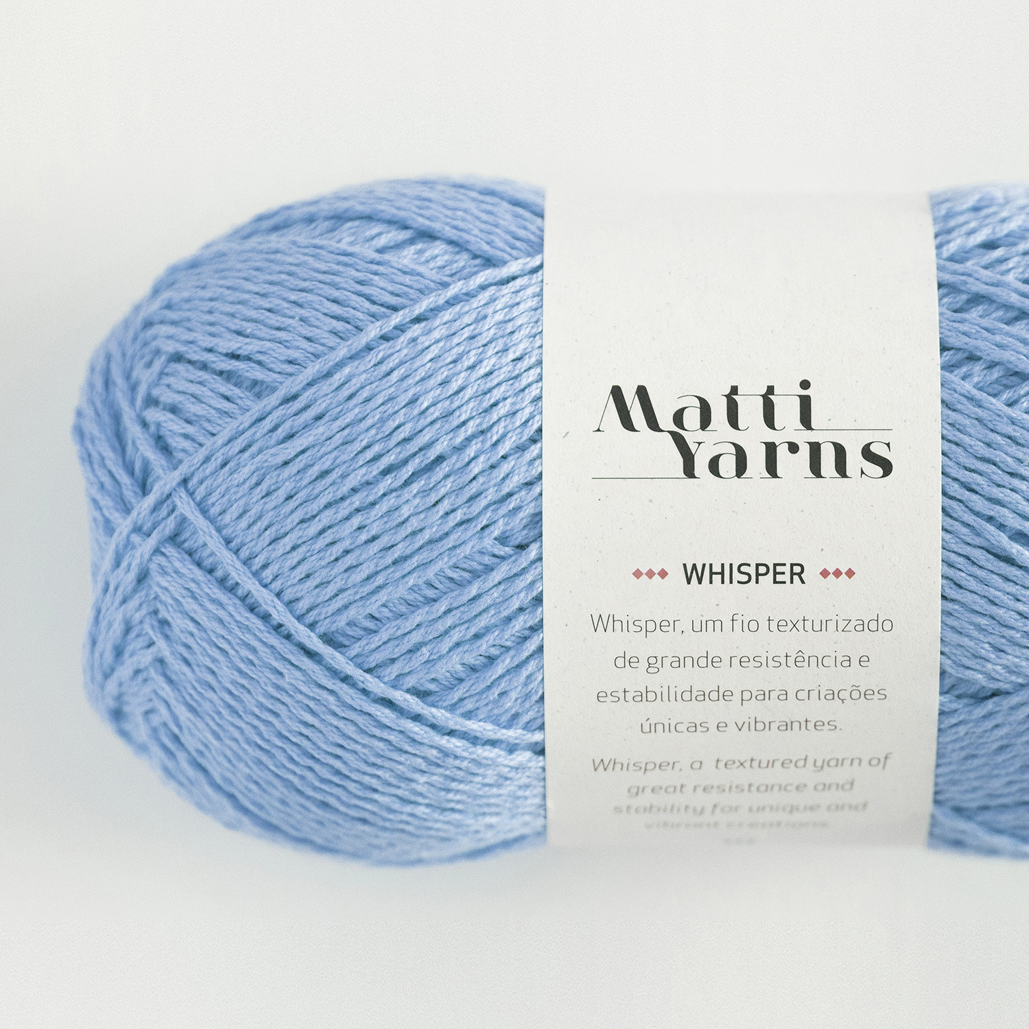 Novelo de fio azul claro com etiqueta branca da marca Matti Yarns modelo Whisper