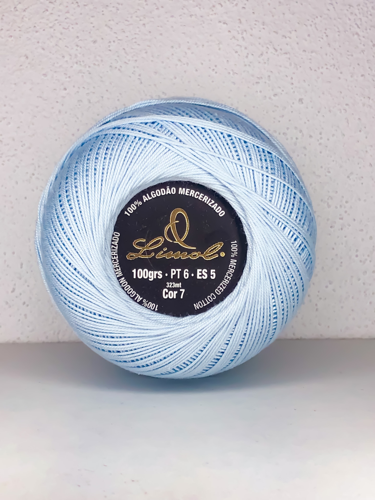 Novelo de linha azul claro de algodão mercerizado com etiqueta preta ao centro