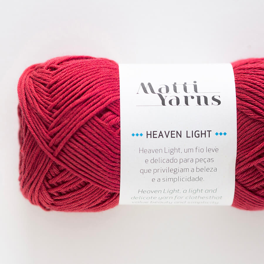 Novelo de fio vermelho da marca Matti Yarns com etiqueta branca e texto