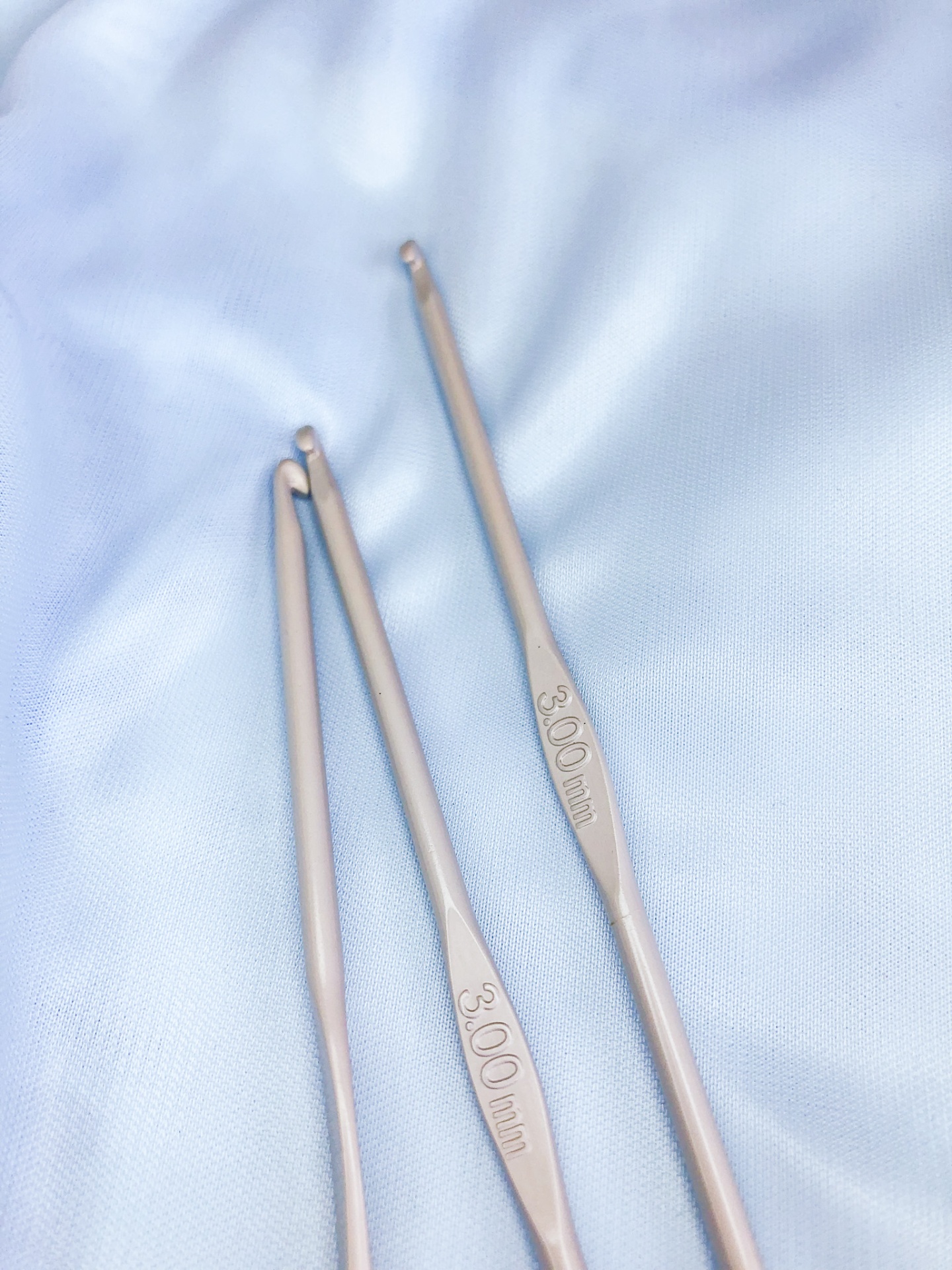 Três agulhas de crochet metálicas com indicação de tamanho 3.00 mm