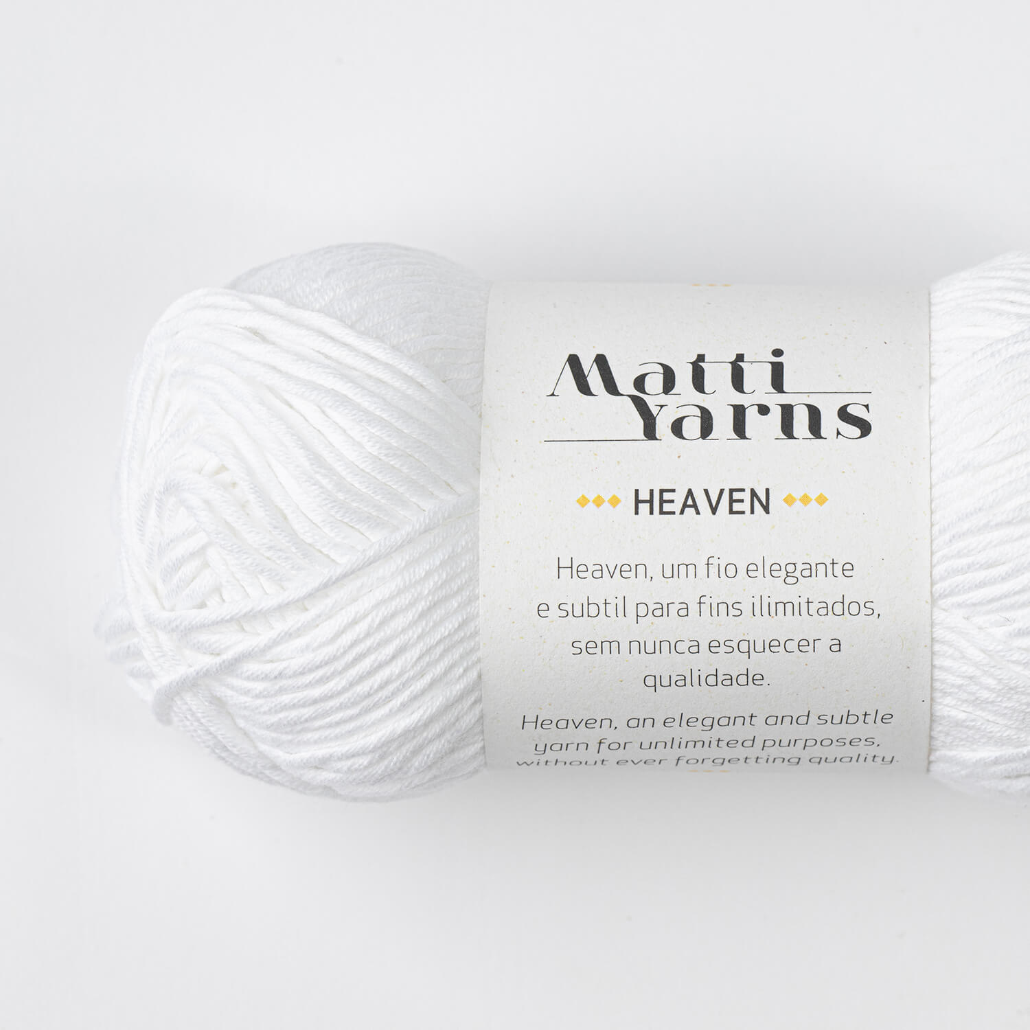Novelo de fio branco da marca Matti Yarns modelo HEAVEN com rótulo explicativo em fundo branco.