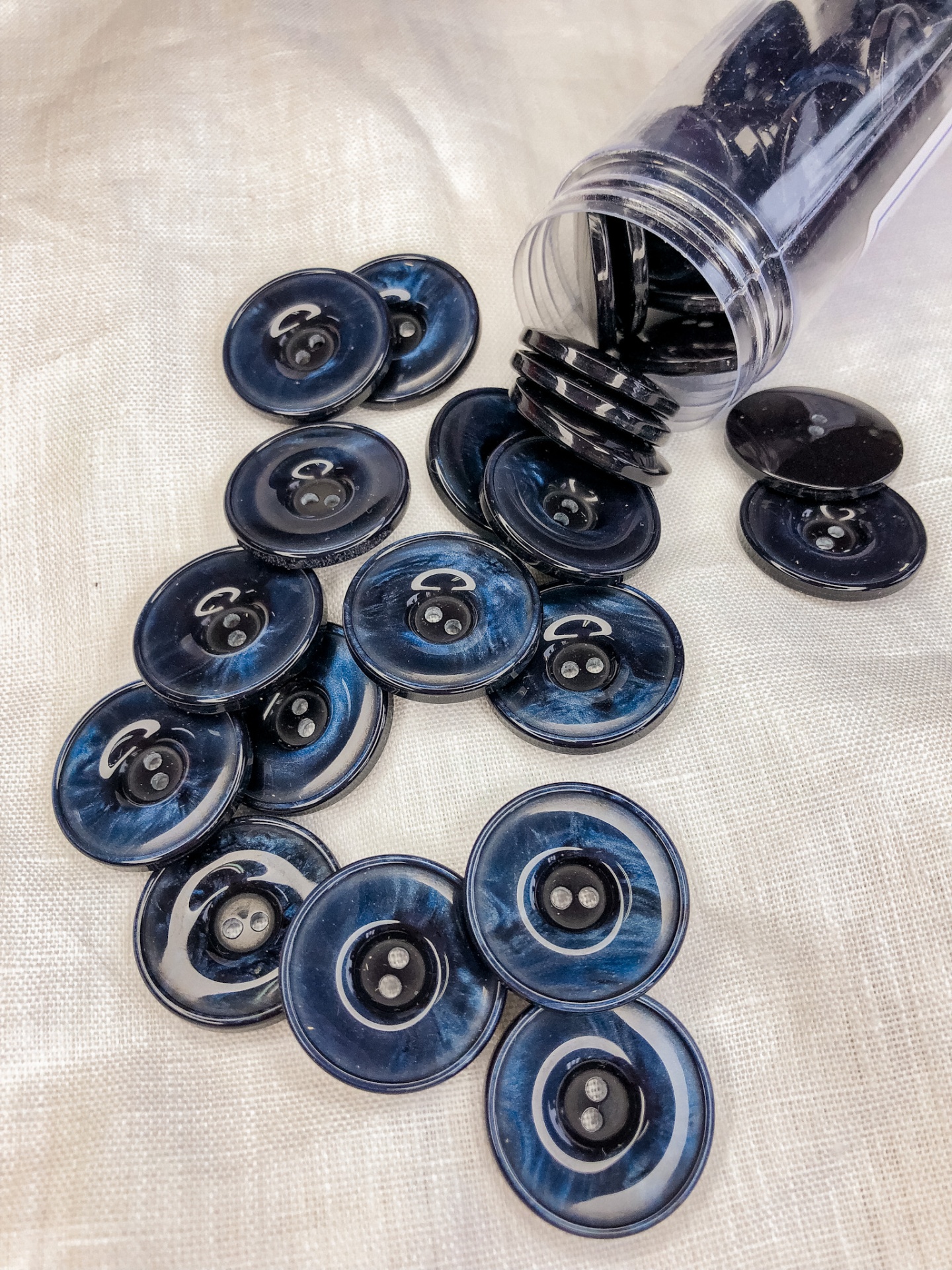 Botões redondos azul escuro com padrão marmoreado sobre tecido claro