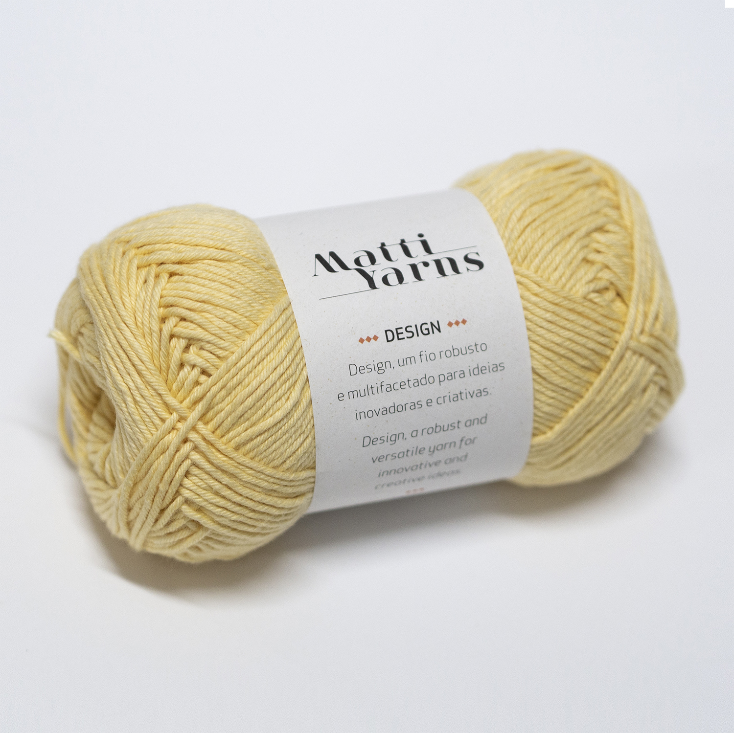 Novelo de lã amarelo claro com rótulo branco da marca Motti Yarns
