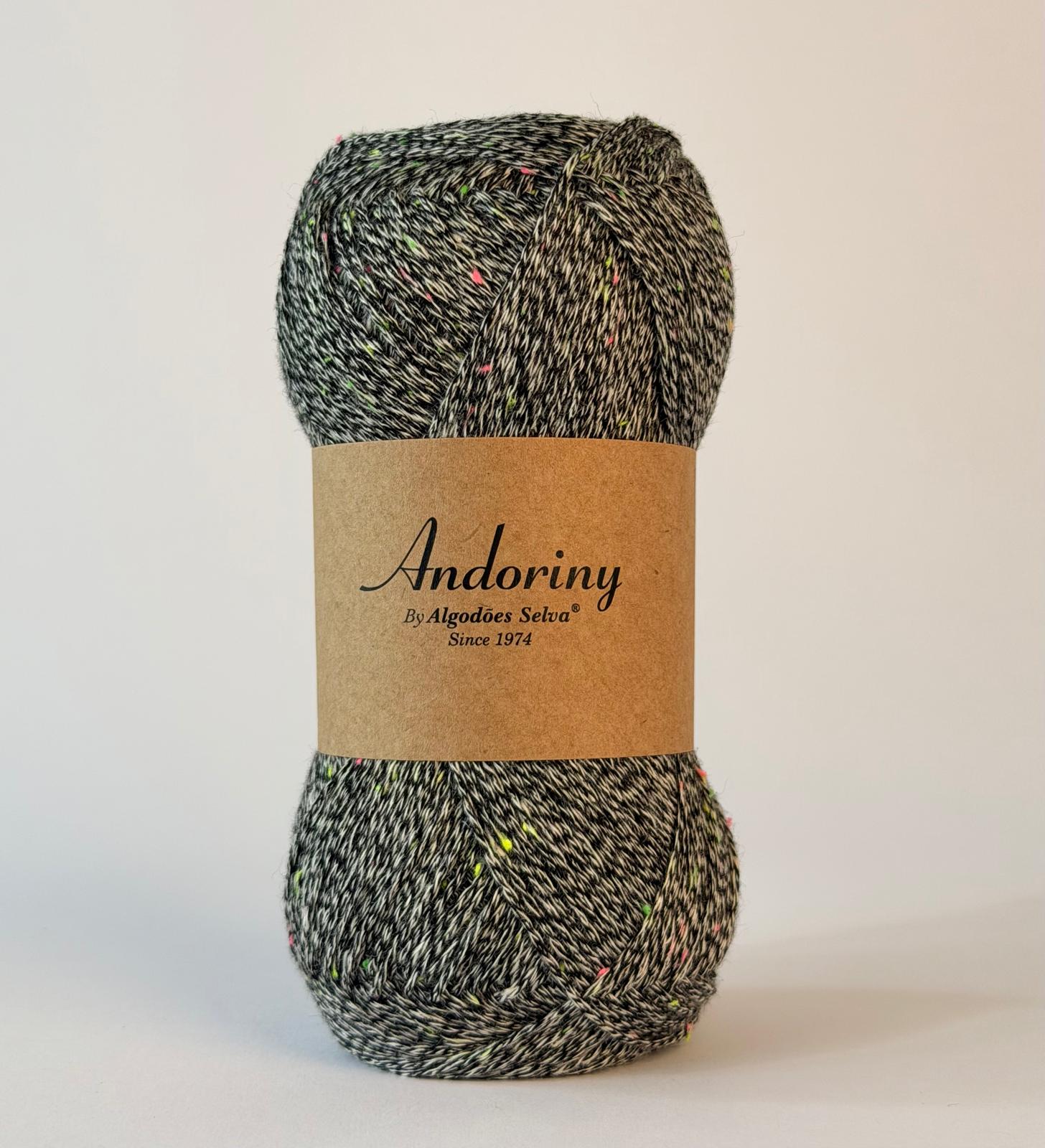 Novelo de lã cinzento com pontos coloridos e rótulo