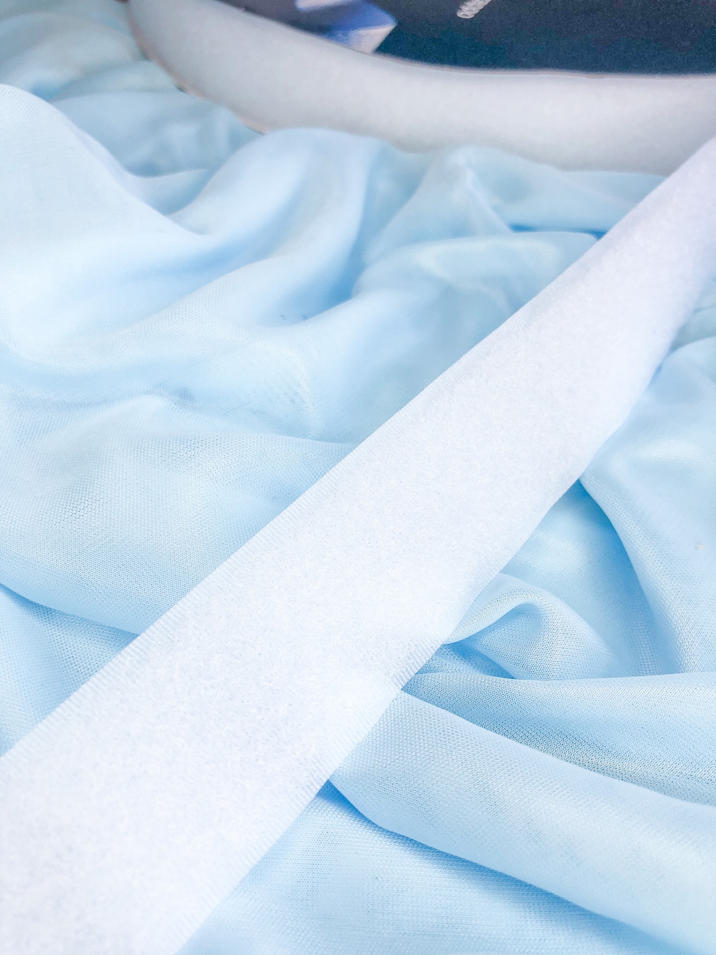 Lenço branco sobre tecido azul claro enrugado