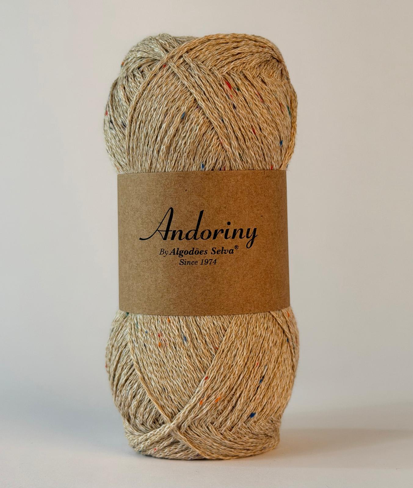 Novelo de fio de algodão bege com pontos coloridos e etiqueta marrom