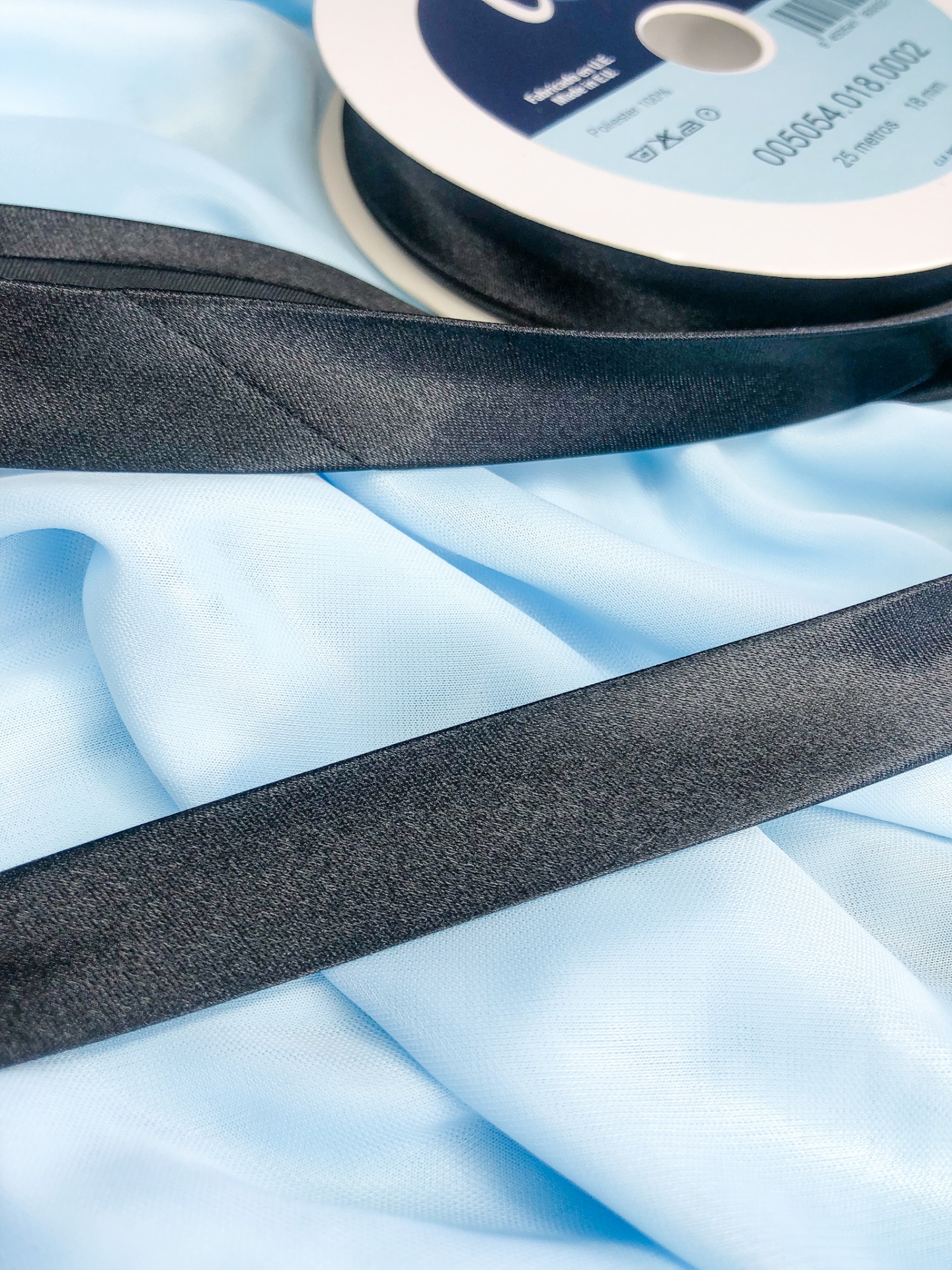 Fita preta em rolo com tecido azul claro por baixo
