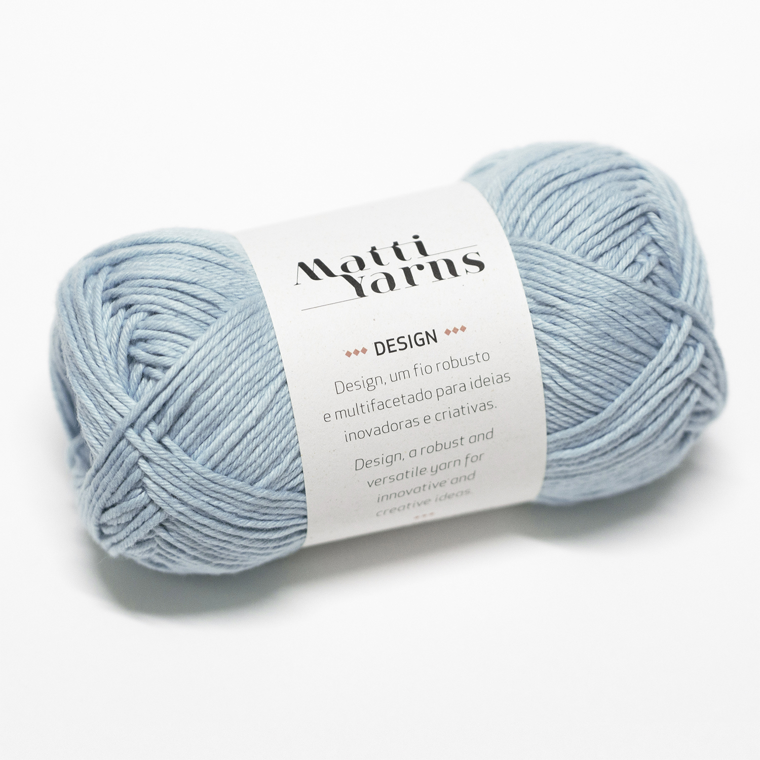 Novelo de fio azul claro com etiqueta branca da Matti Yarns em fundo branco