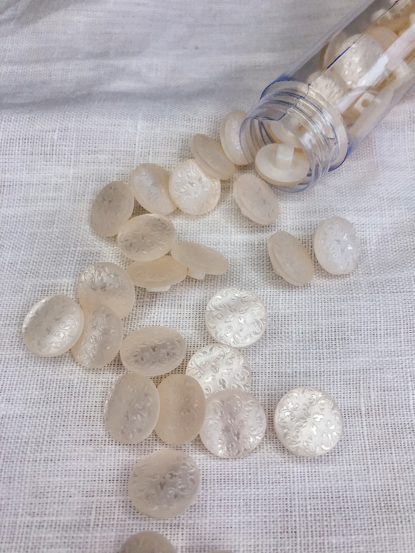 Botões transparentes redondos com textura floral em tecido branco