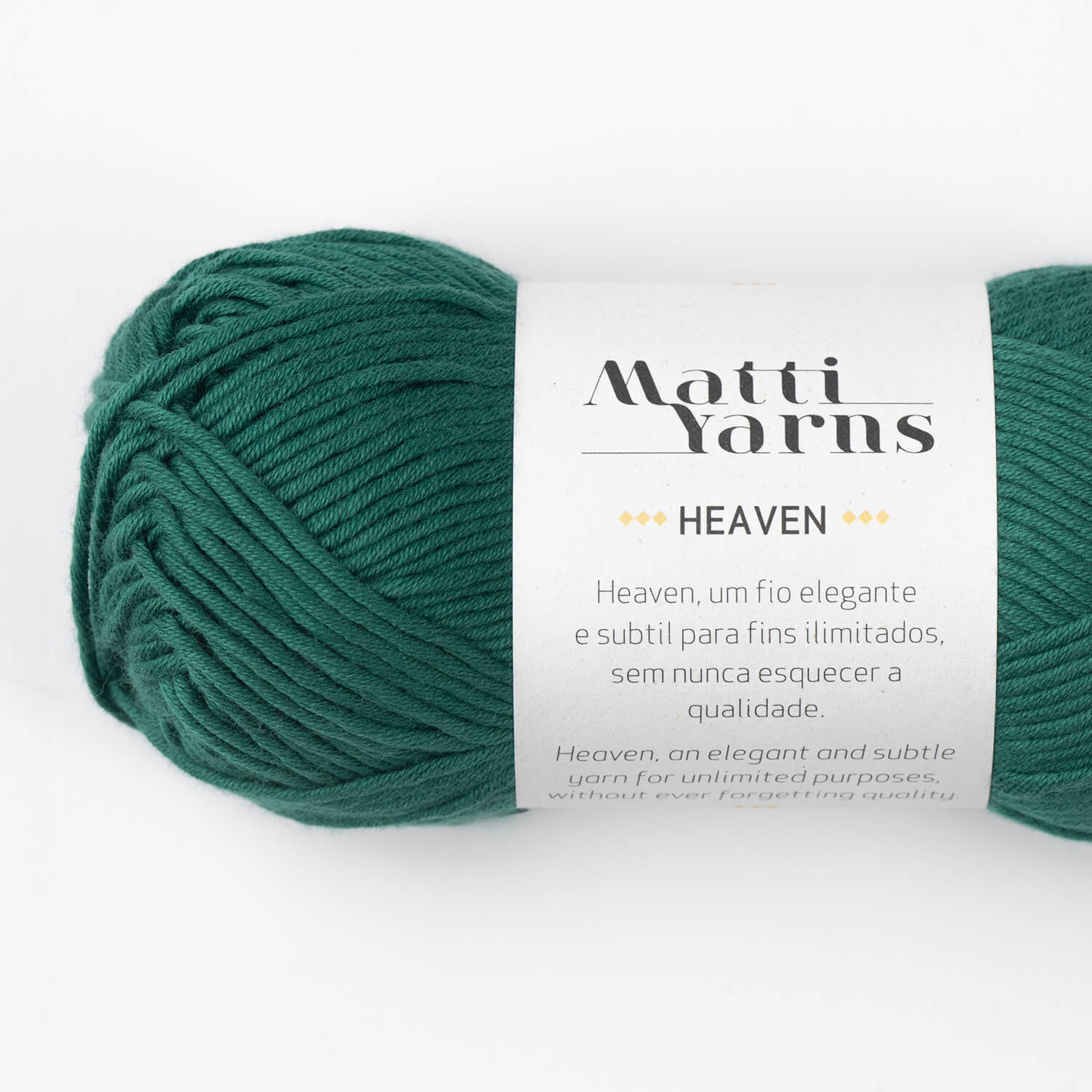 Novelo de fio de lã verde escuro com rótulo branco e texto em preto e dourado.