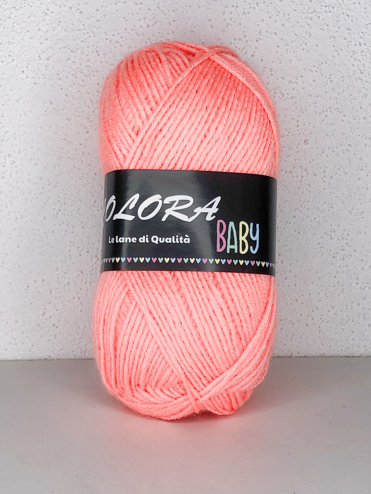 Novelo de lã rosa claro com etiqueta preta