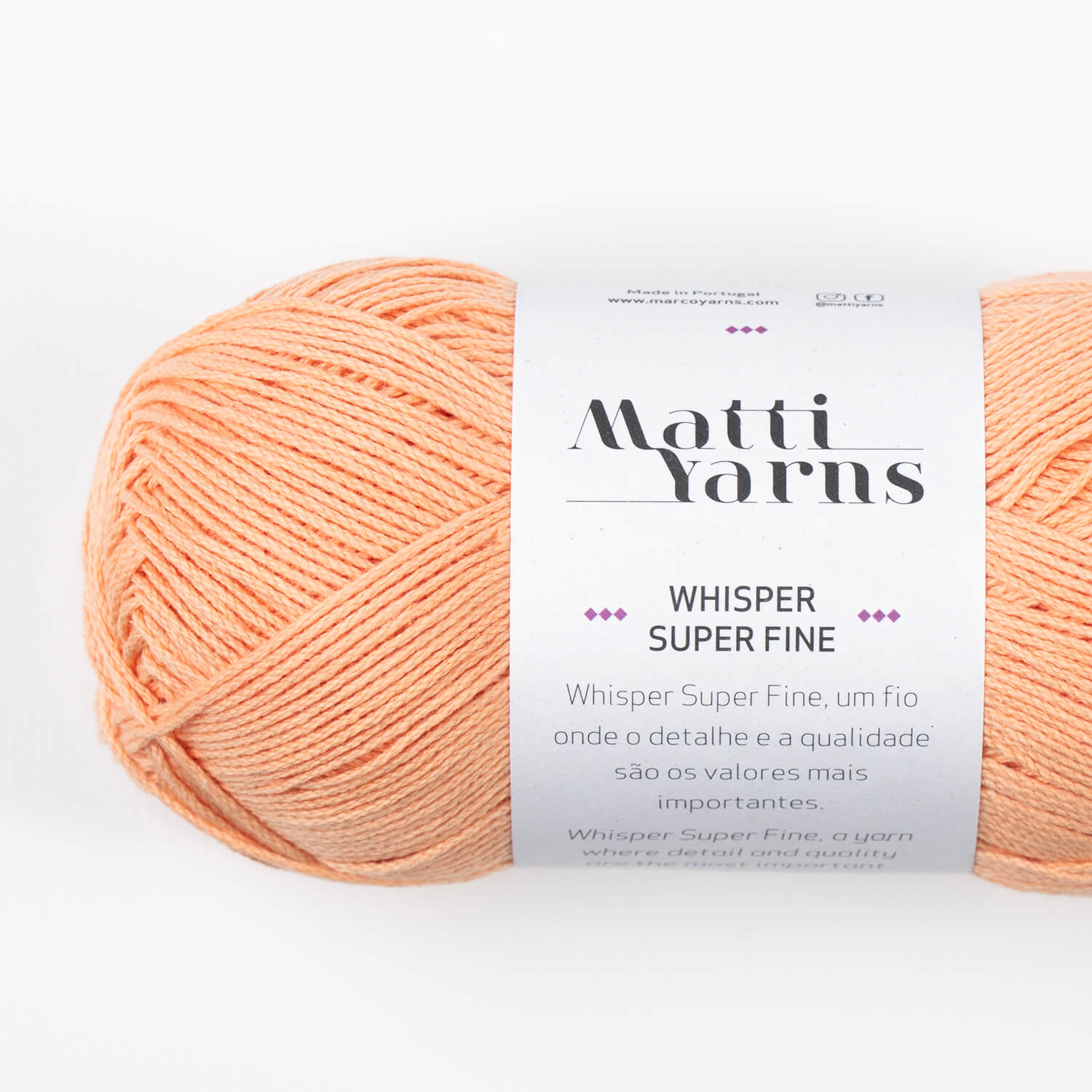 Rolo de fio de lã cor pêssego claro com etiqueta branca e texto