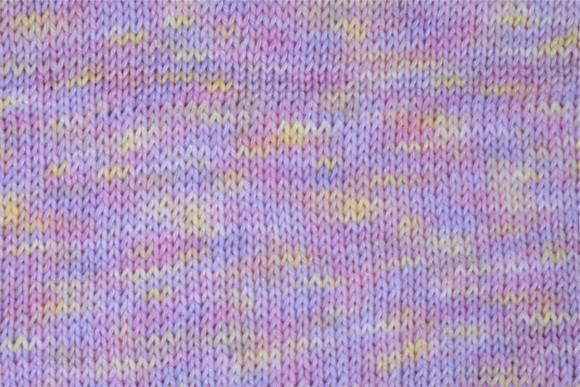 Tecido de malha lilás com padrões amarelos e rosas