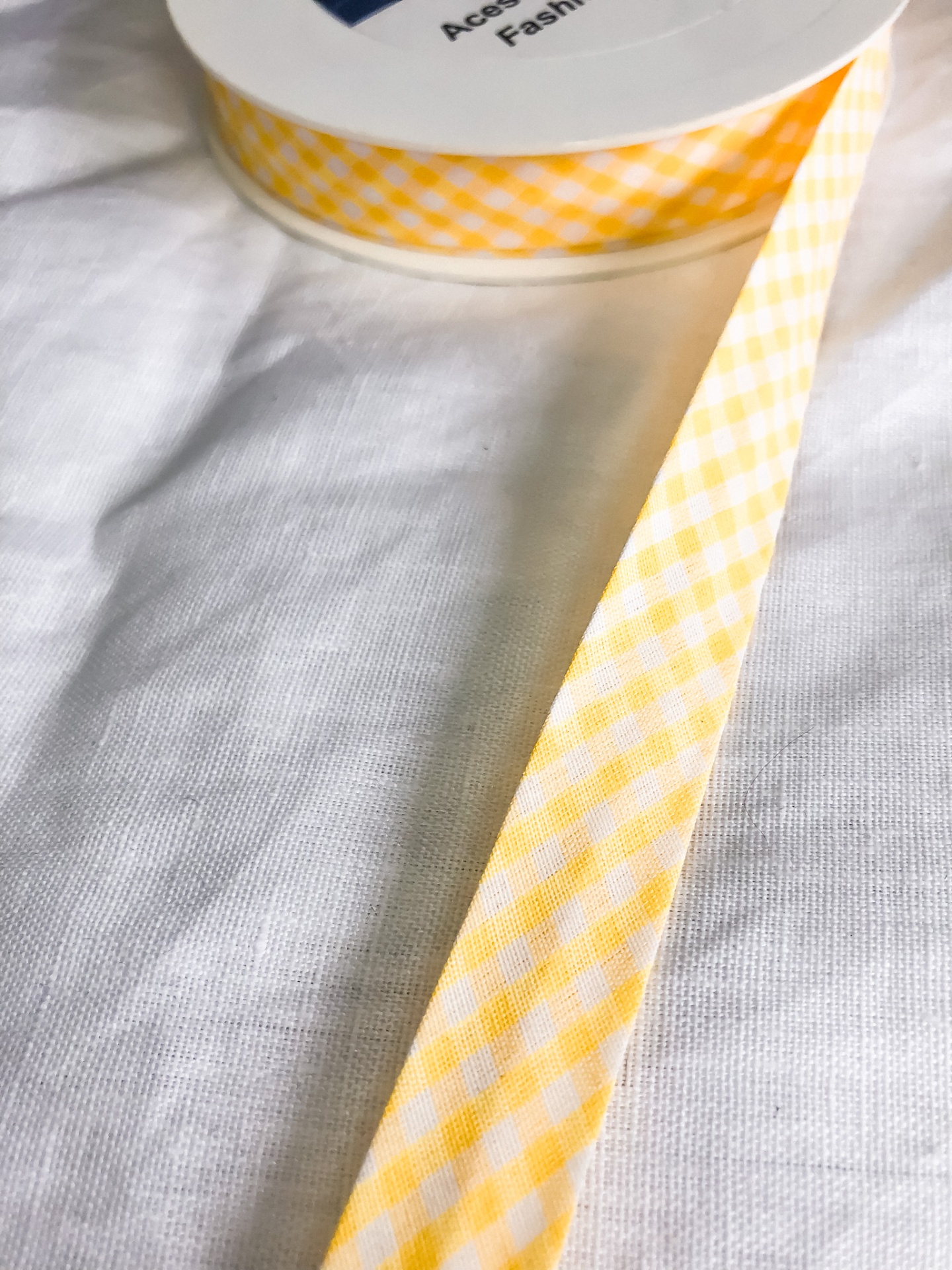 Fita de tecido xadrez amarelo e branco sobre tecido branco