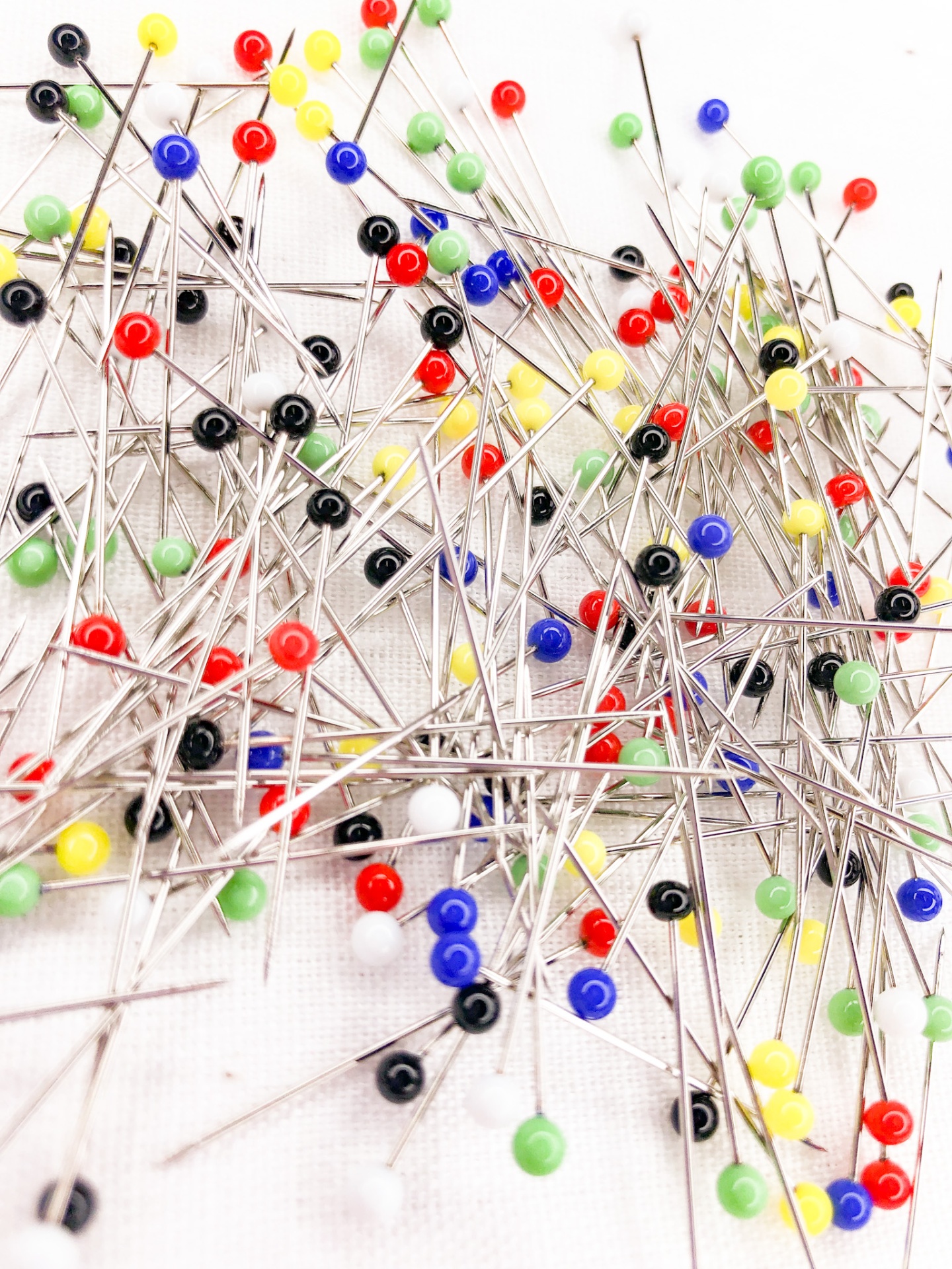 Alfinetes coloridos de cabeça redonda sobre fundo branco