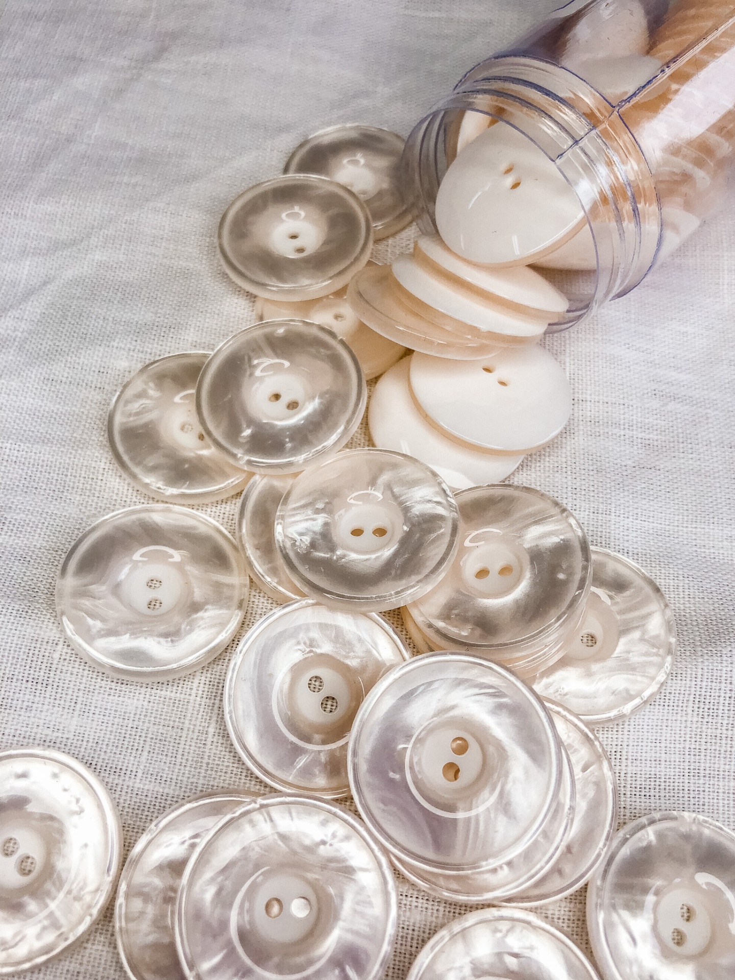 Botões perolados transparentes e opacos em tecido branco
