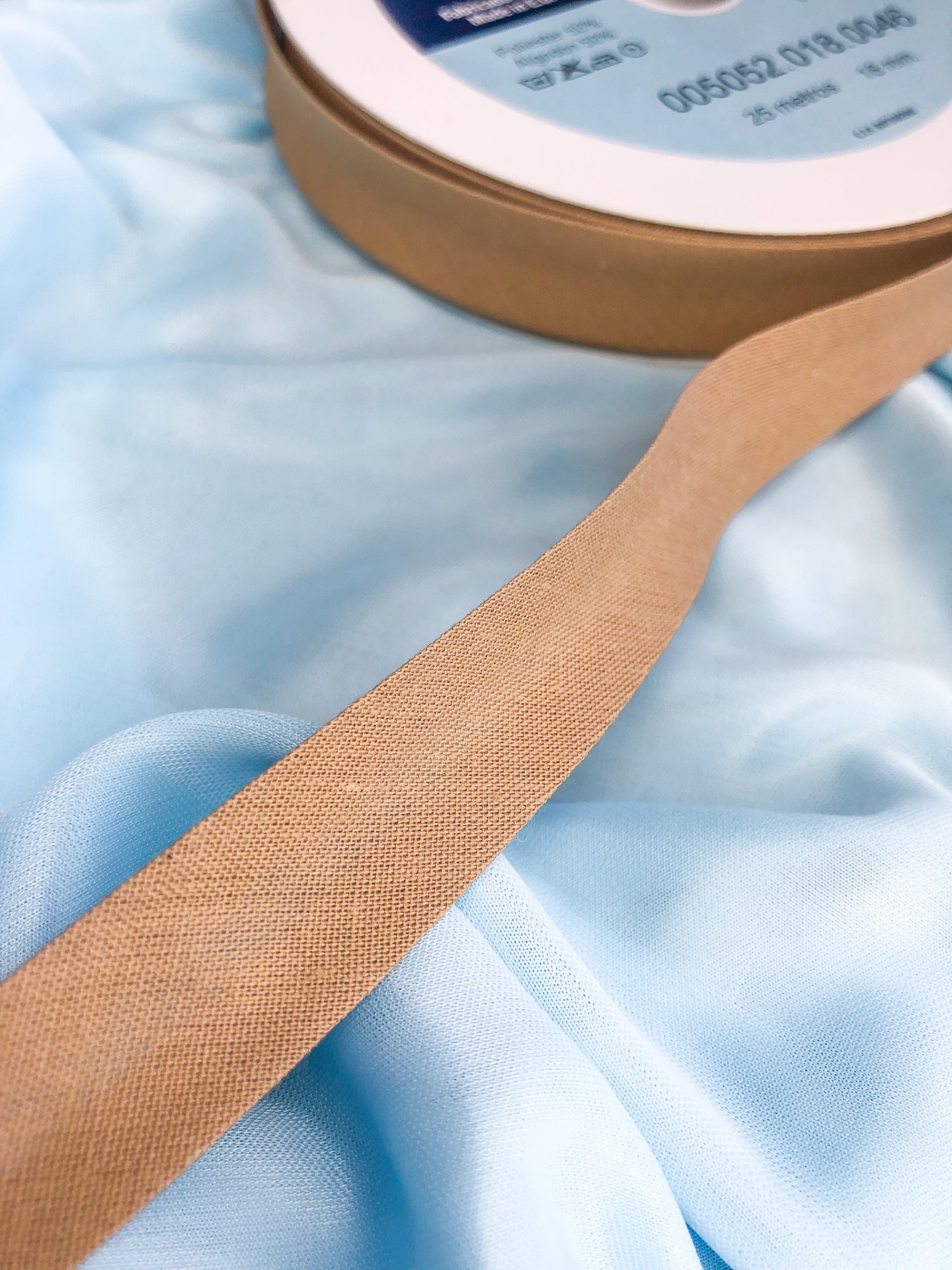 Fita bege em tecido sobre tecido azul claro brilhante