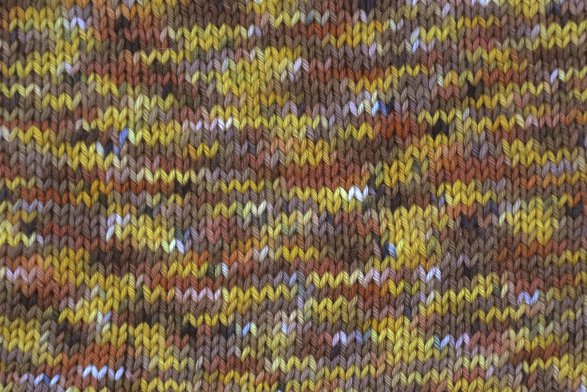 tecido de malha colorido com padrões em tons terra e amarelo