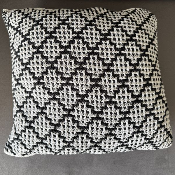 Almofada quadrada preta e branca com padrão geométrico