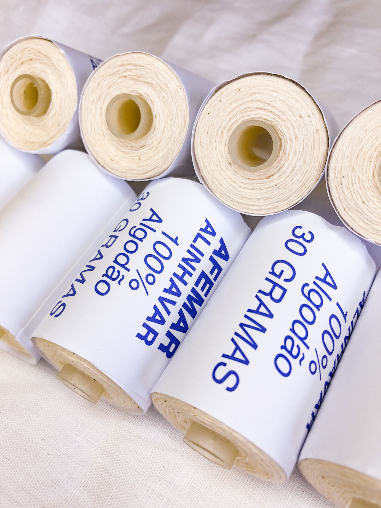 Rolos de algodão 100% com etiquetas e texto azul