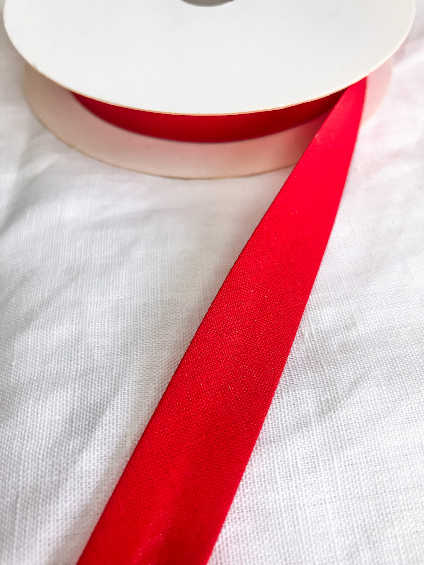 Rolo de fita vermelha em tecido com textura lisa.