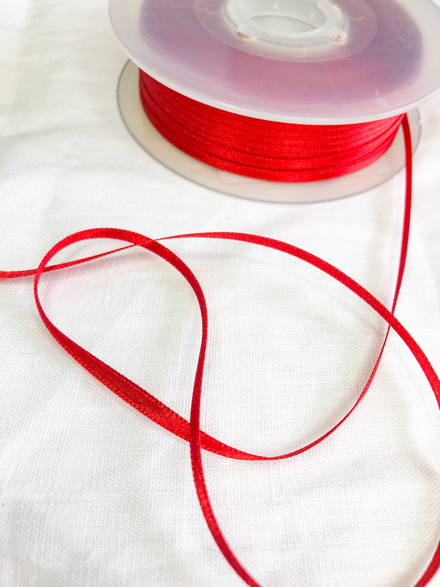 Rolo de fita vermelha em tecido branco