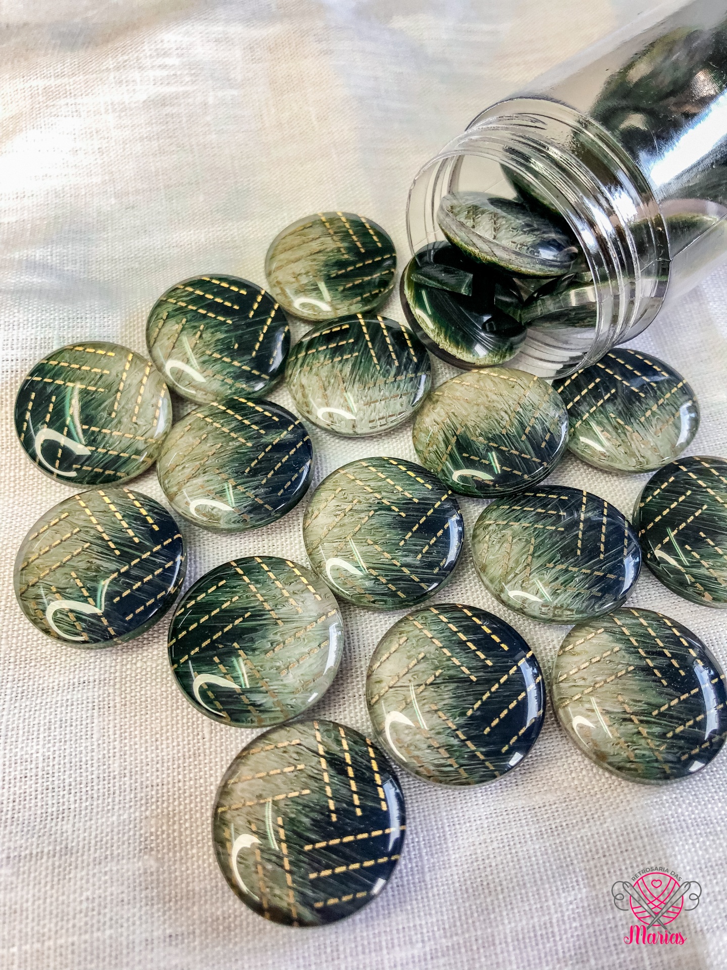 Botões redondos verdes com padrão dourado sobre tecido claro
