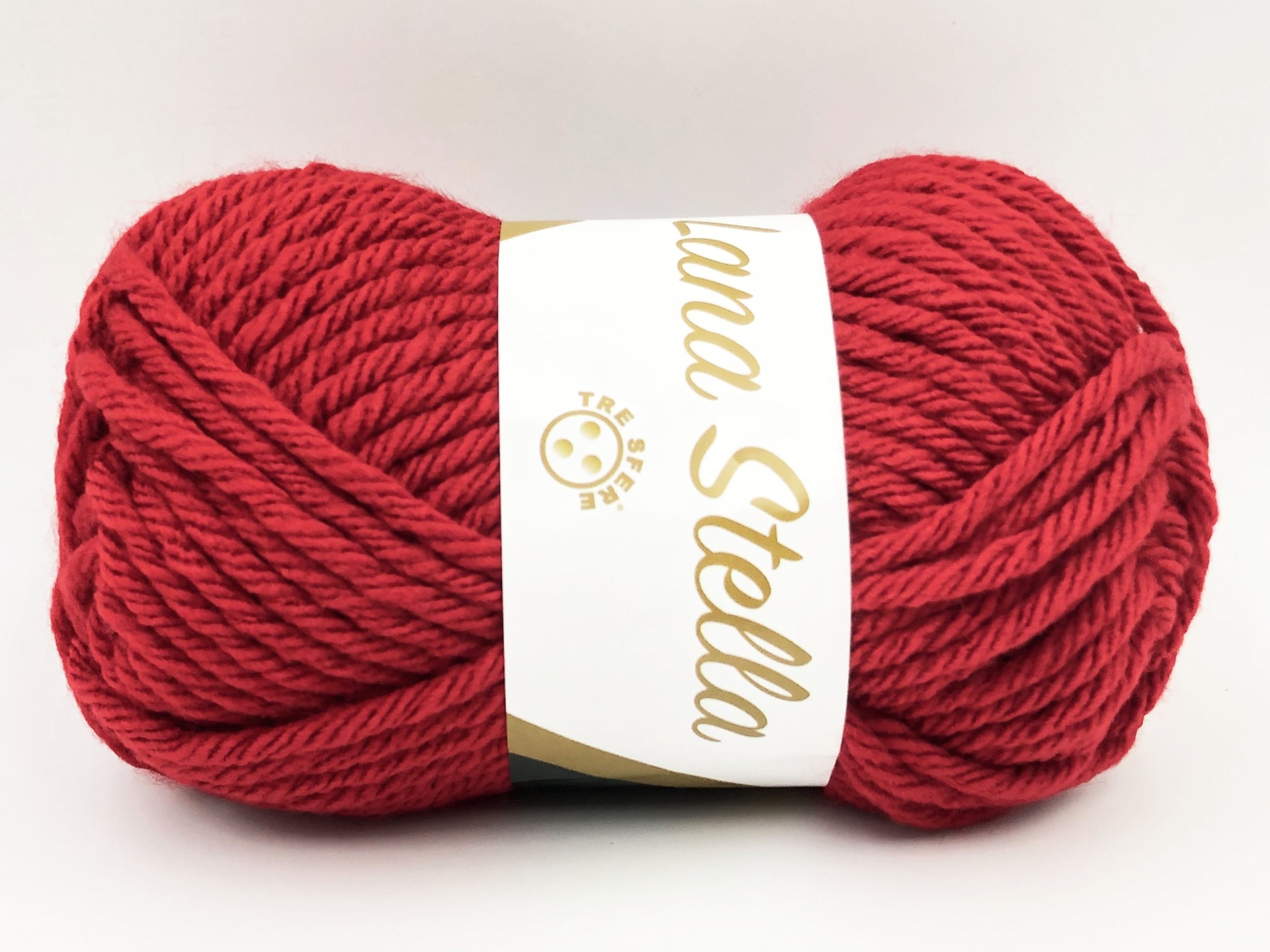 Novelo de lã vermelha com etiqueta branca e texto dourado