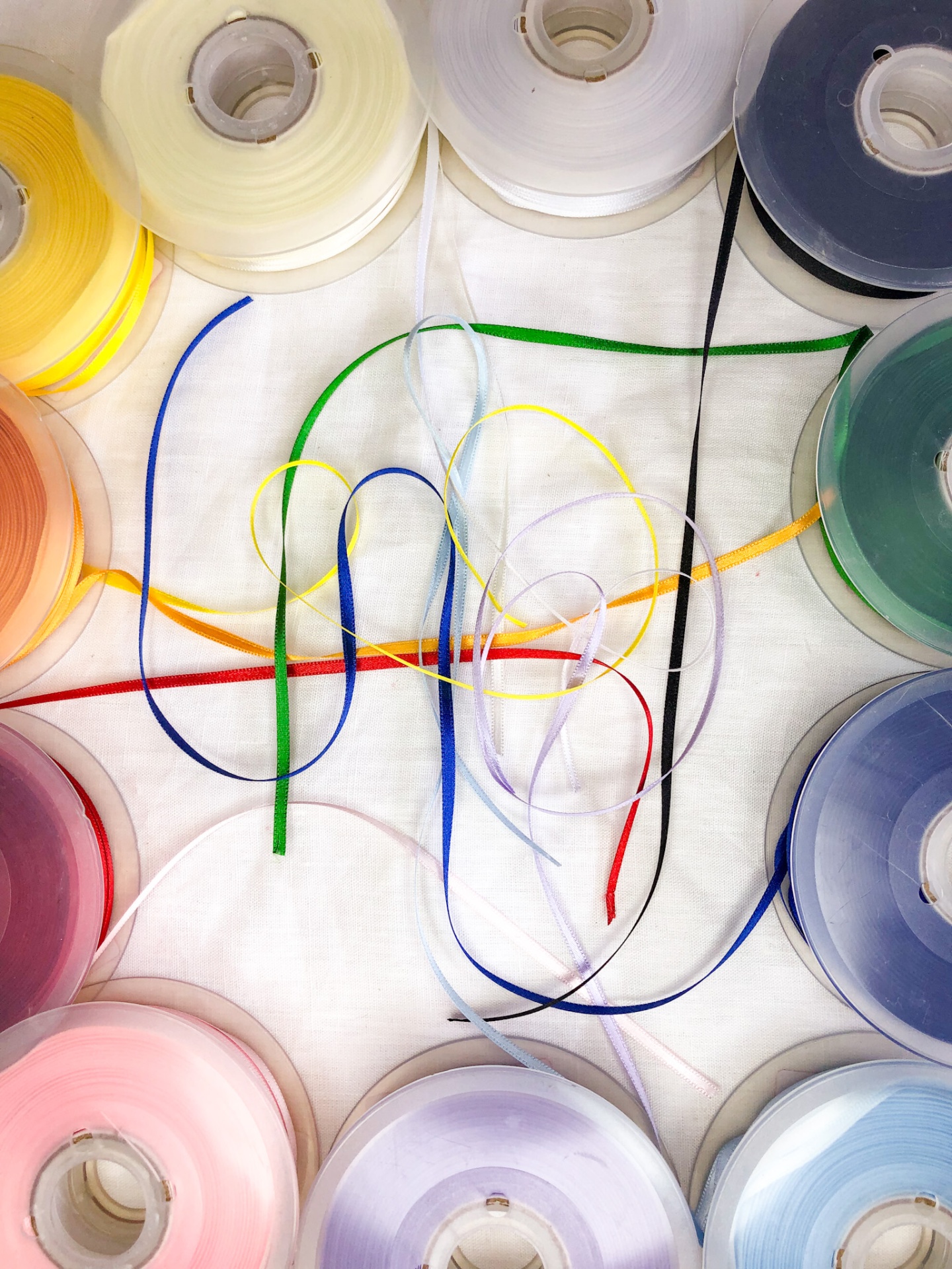 Rolos coloridos de fita decorativa em círculo com fitas desenroladas no centro