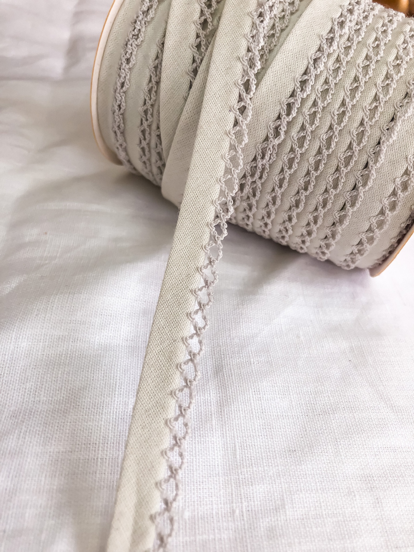 Rolo de fita de tecido bege com bordado castanho claro