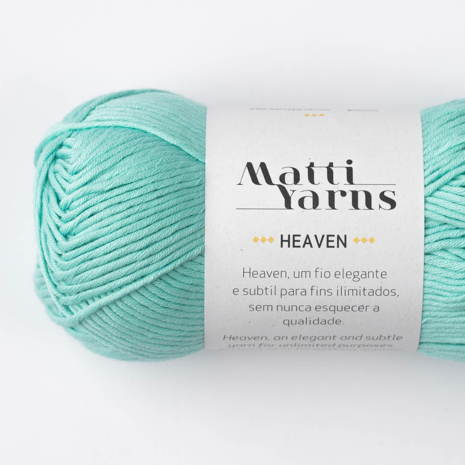 Rolo de fio verde água Matti Yarns Heaven com etiqueta branca em fundo branco