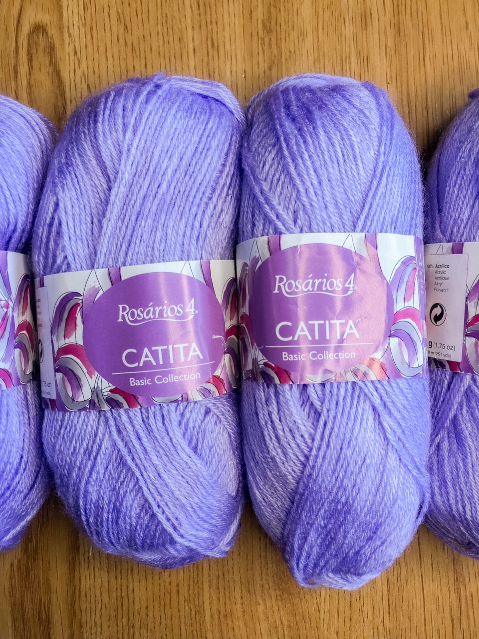 Novelos de lã lilás claro da marca Rosários 4 Catita Basic Collection sobre madeira