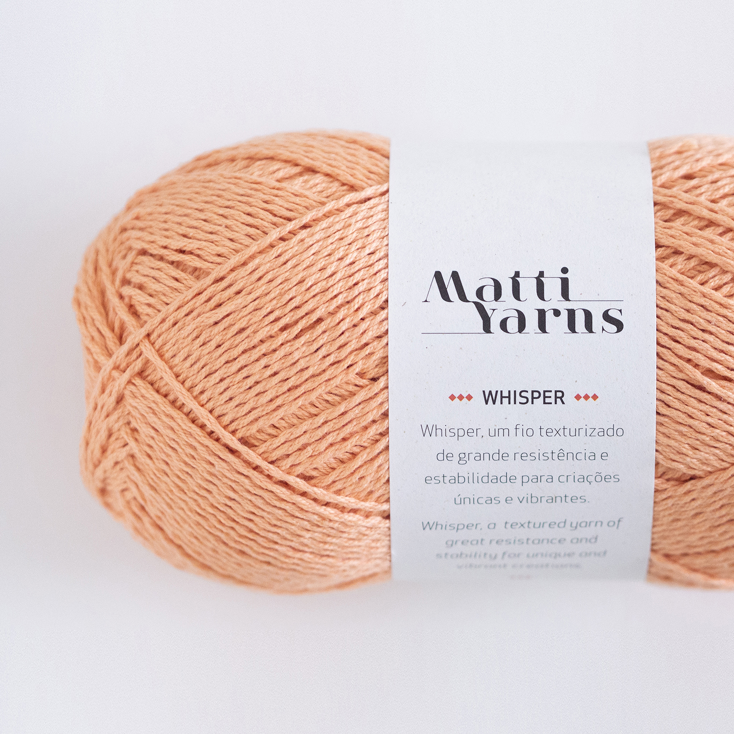 Novelo de fio cor de pêssego Matti Yarns Whisper com etiqueta branca
