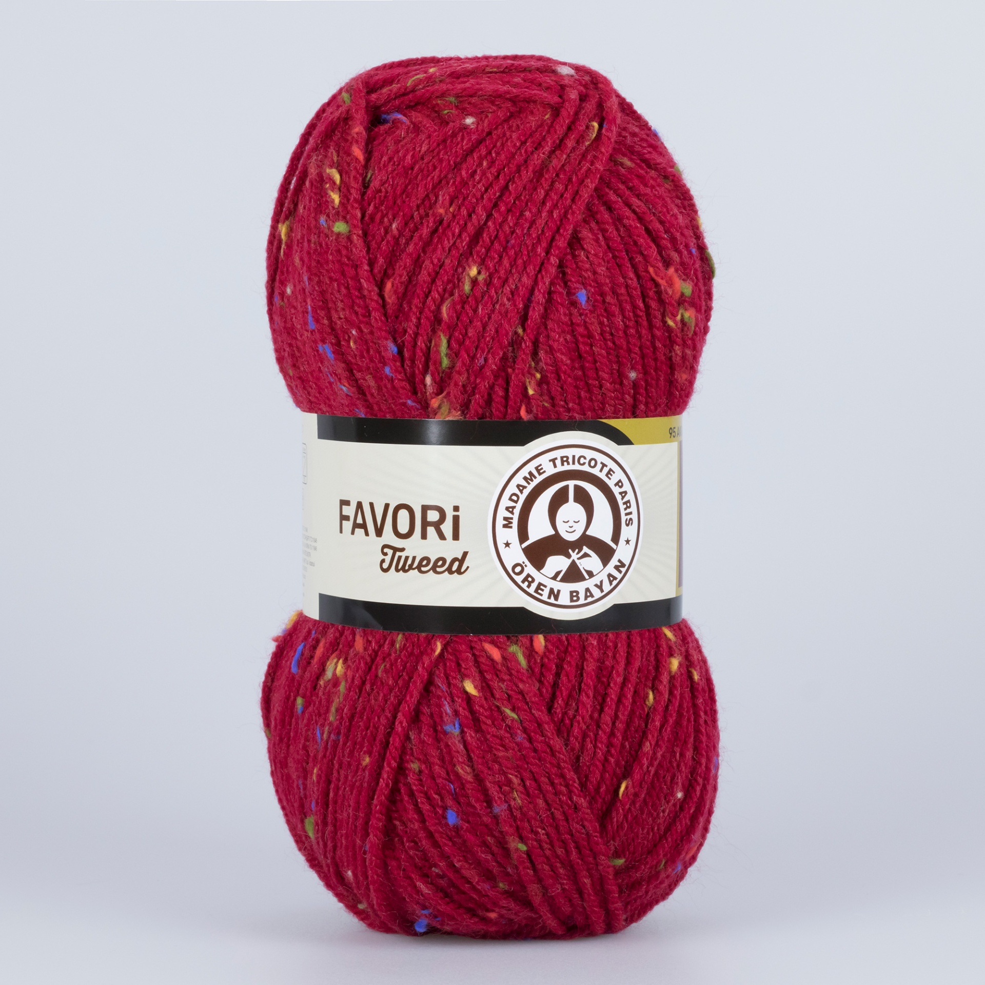 Novelo de fio de lã vermelho com manchas coloridas e etiqueta branca com texto.