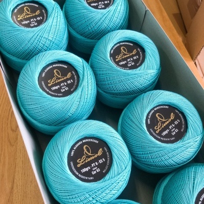 Esferas de linha azul-turquesa com etiquetas negras em caixa branca