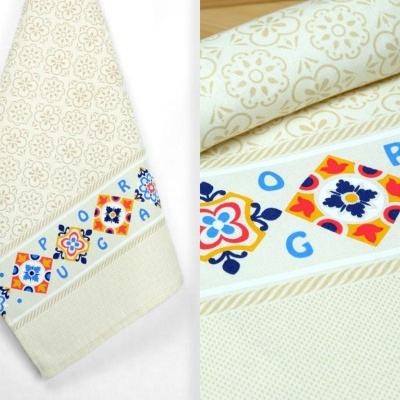 Toalha creme com padrão floral e faixa decorativa com azulejos coloridos