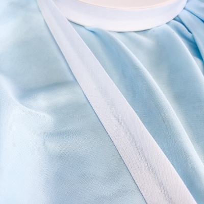 Fita branca numa bobina sobre tecido azul claro