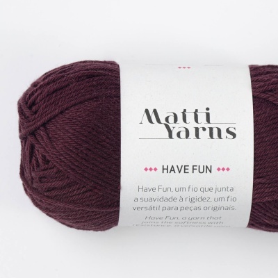 Novelo de fio bordeaux da marca Matti Yarns com rótulo branco contendo texto descritivo.