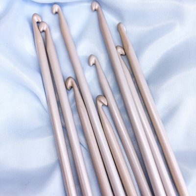 Conjunto de agulhas de tricô metalizadas em tecido branco