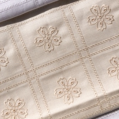 Tecido bege com flores bordadas e padrão em quadros