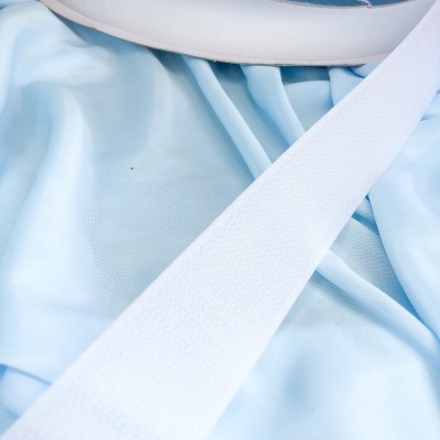 Rolo de fita adesiva branca sobre tecido azul claro