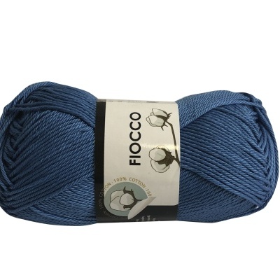 Novelo de fio azul escuro 100% algodão com etiqueta branca e escrita 'FIOCCO'