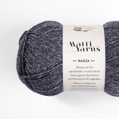 Novelo de fio cinza azulado mesclado com etiqueta branca e texto informativo